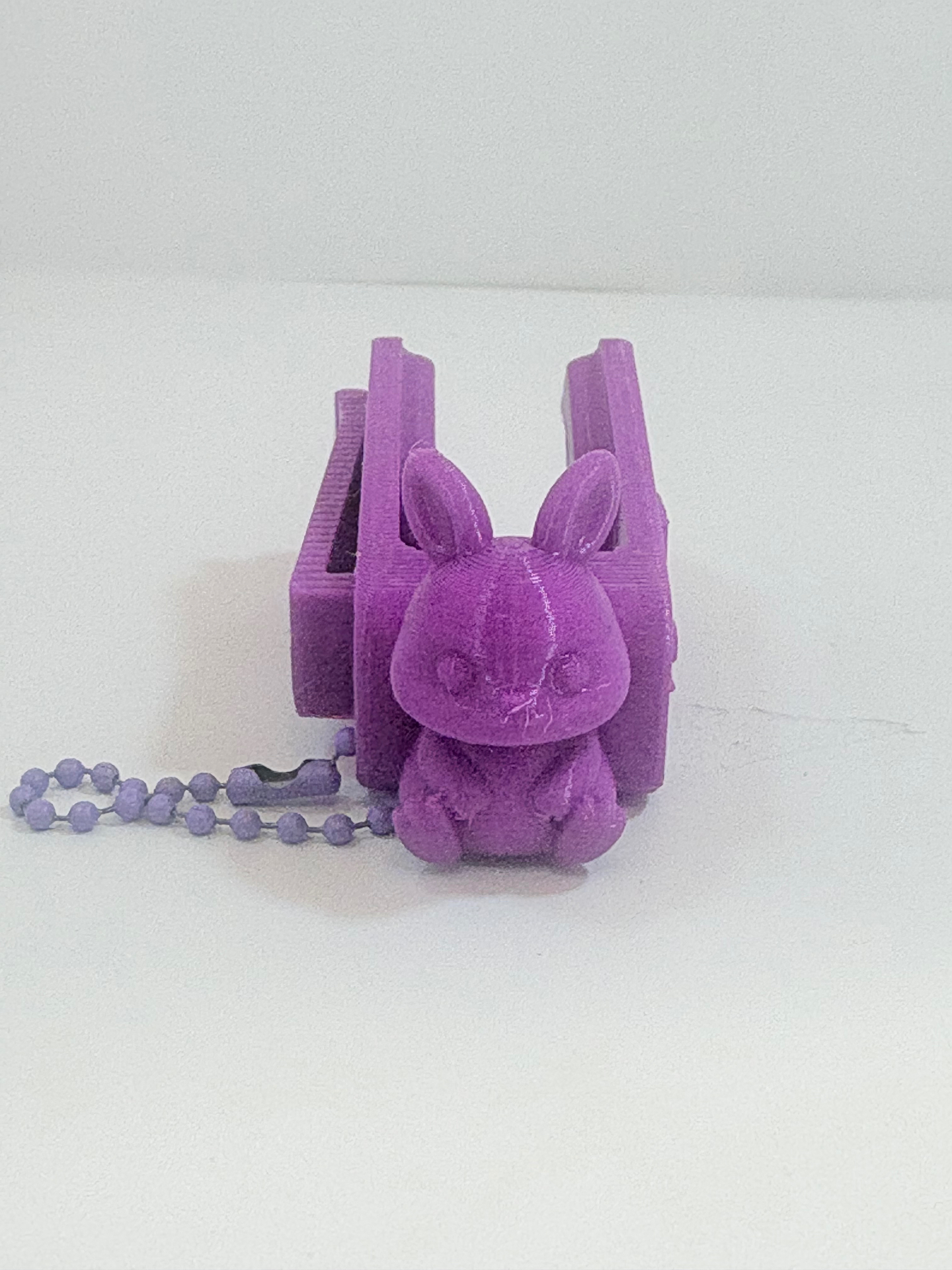 MamoSpin Pufli — coelho roxo de frente, sentado no prendedor