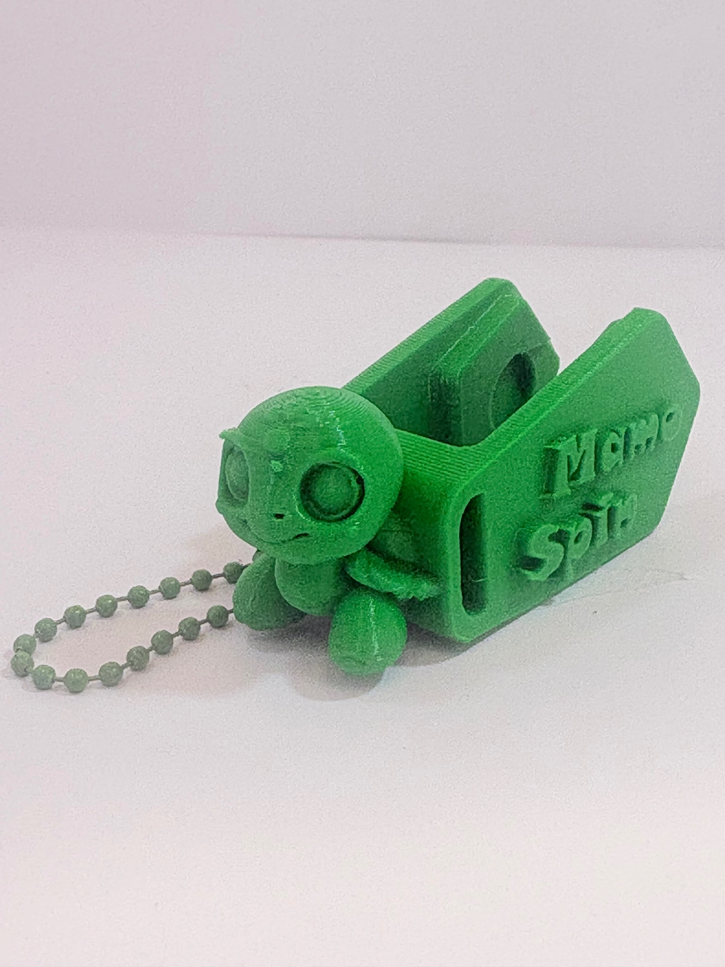 MamoSpin Kelpi — tartaruga verde de lado, mostrando o prendedor Mamo Spin