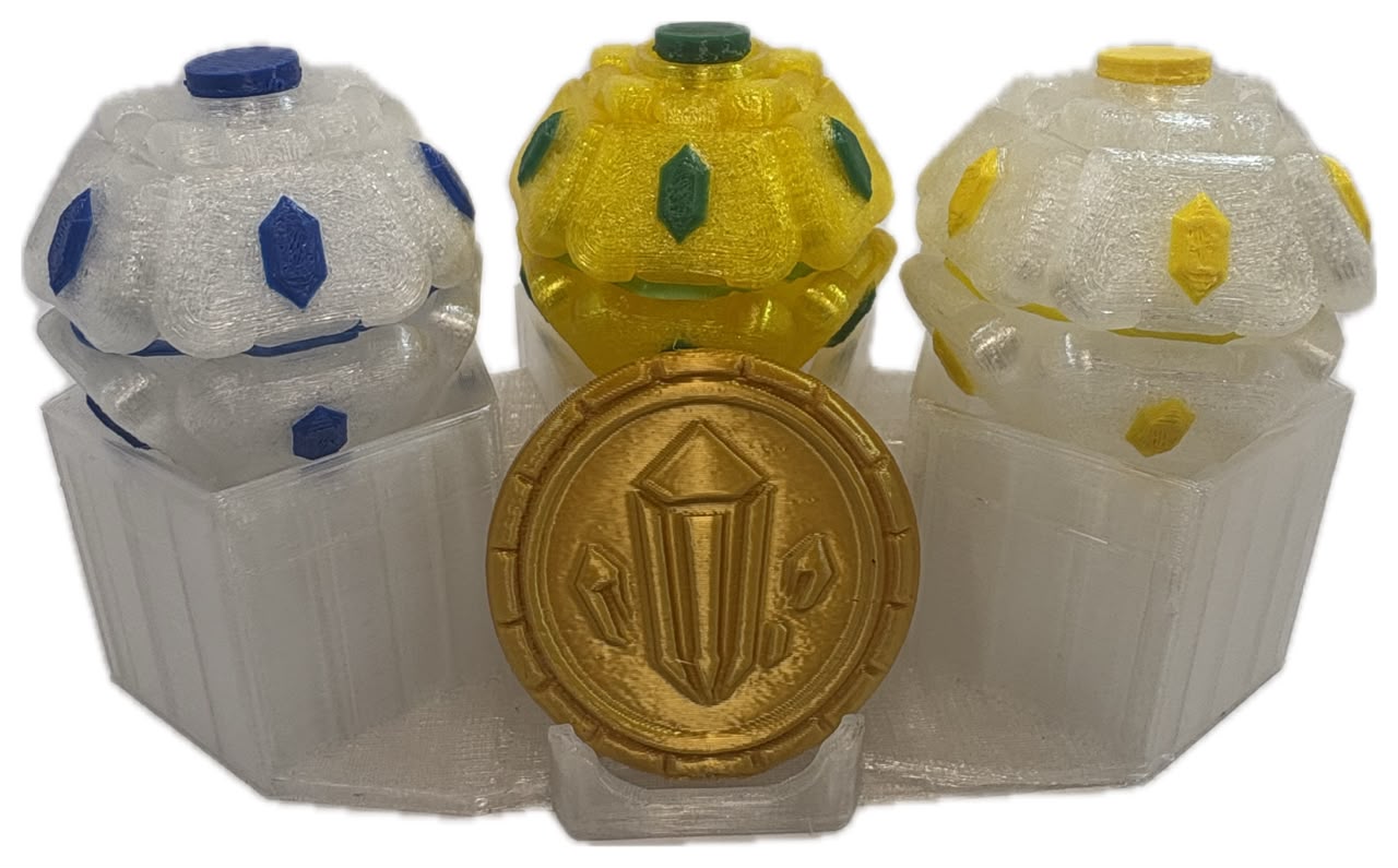 Pack da família Místicos: três Mamolitks translúcidos com MamoCoin dourada em expositor transparente