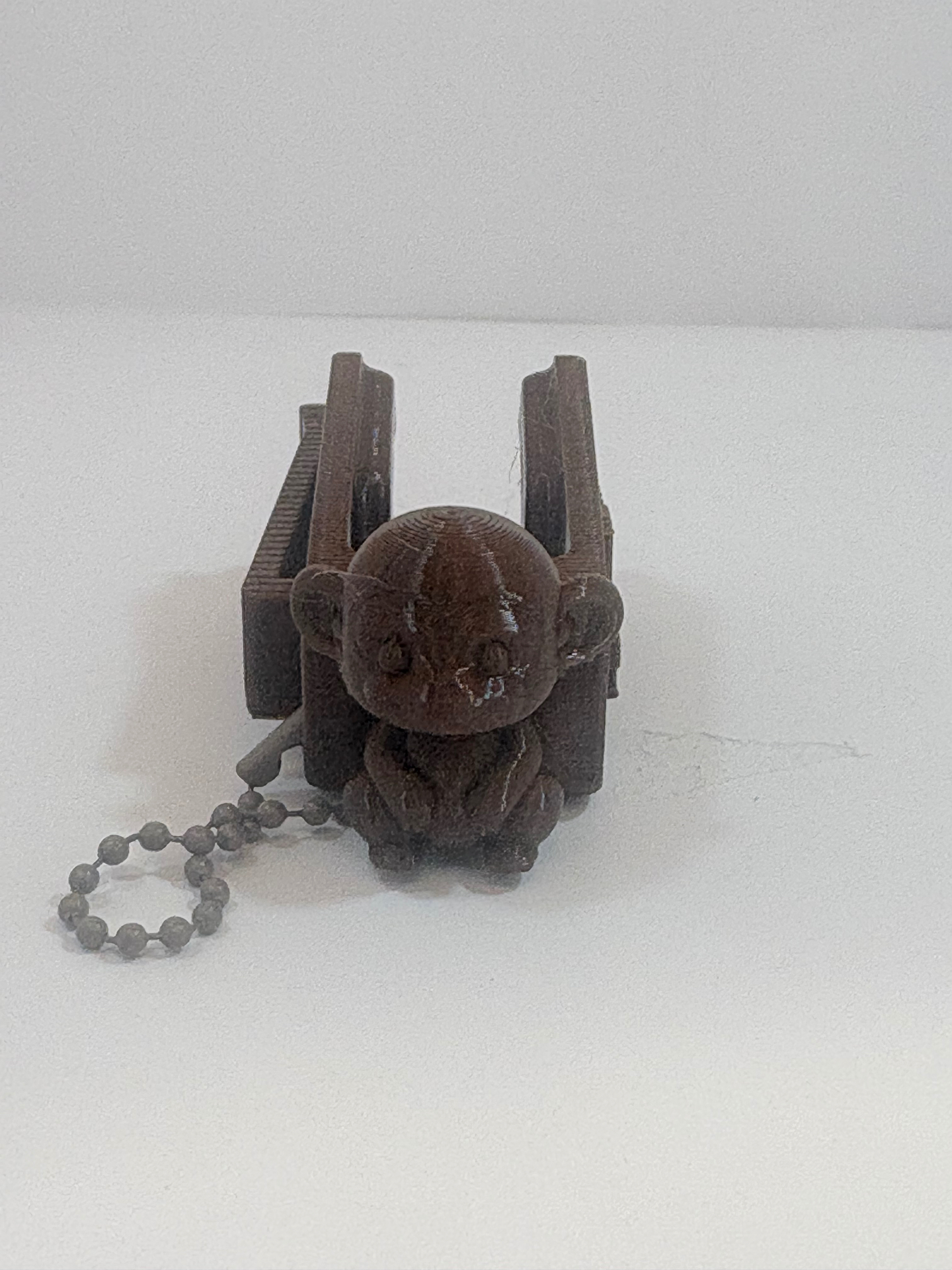 MamoSpin Bruki — macaco marrom sentado no prendedor